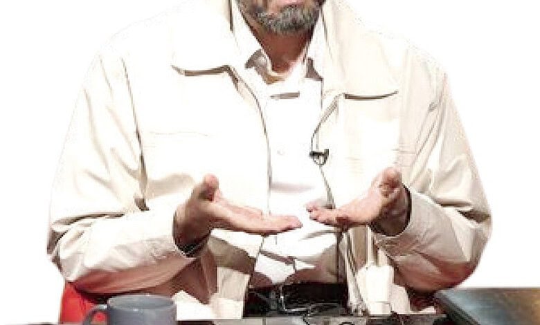 مردی در حال صحبت کردن با دست‌ها در یک گفتگوی سیاسی.